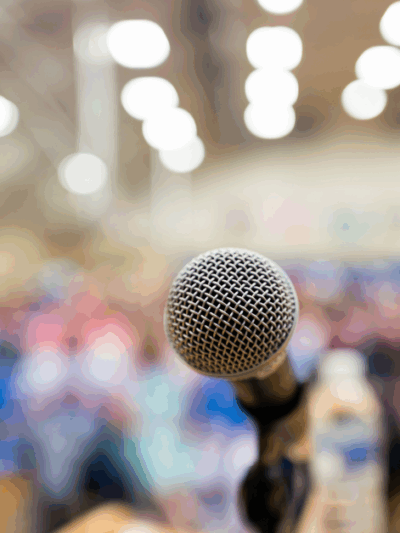 A microphone in front of a seated crowd