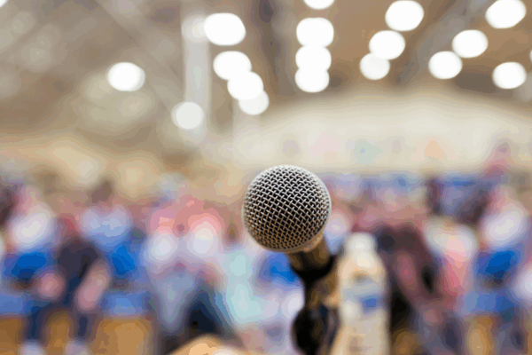 A microphone in front of a seated crowd