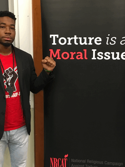 Mark Hopkins, a survivor of solitary confinement, stands next to the words "Torture is a Moral Issue."