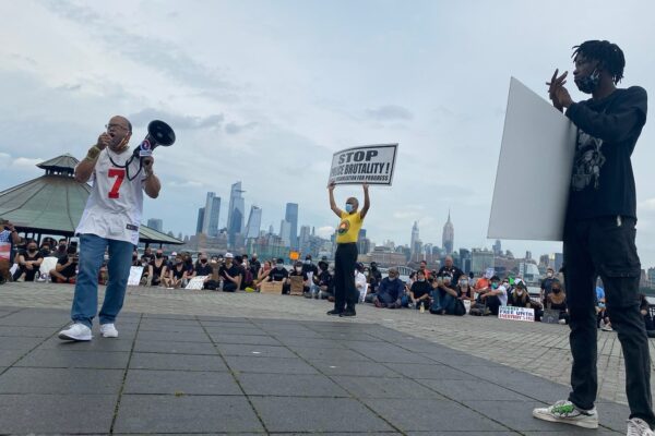 Zayid Muhammad holds a megaphone at a People's Organization for Progress rally