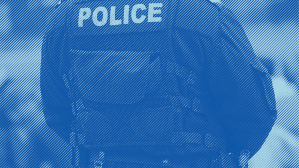 An image of the back of some where wearing a police vest and uniform with a blue stripped treatment applied.