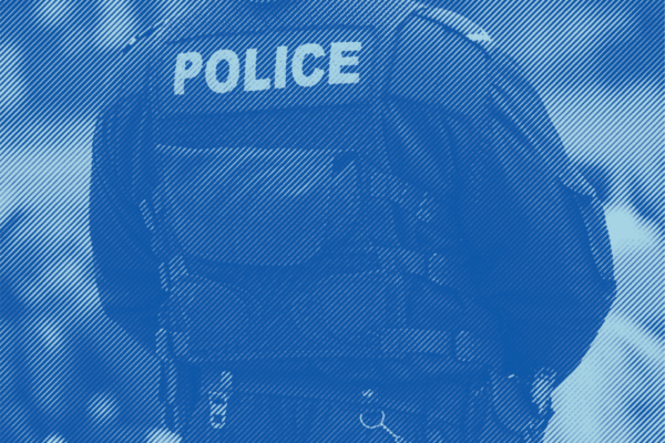 An image of the back of some where wearing a police vest and uniform with a blue stripped treatment applied.