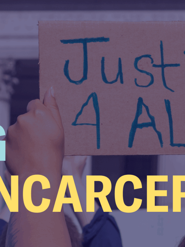 The words "Ending mass incarceration" are laid over an image of hands holding a sign that says "Justice 4 All"