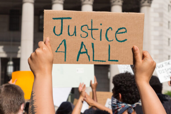 Hands holding up a sign with word