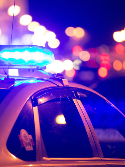 Cop car with lights flashing at night