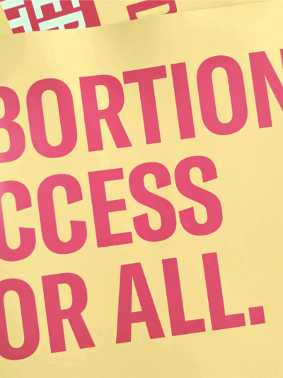 red text on yellow backgrond reading "Abortion Access for All"