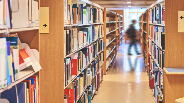 School library shelves with a blurred image of a person walking