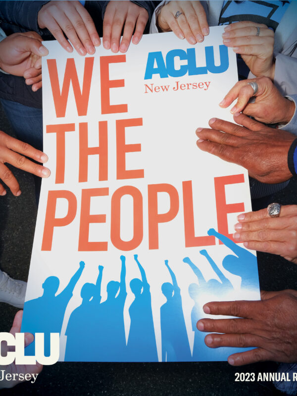 Hands holding a sign that reads "We The People," with an ACLU-NJ logo and the words 2023 Annual Report