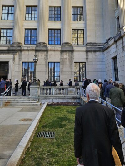 A line of people waiting to testify at the OPRA hearing wraps around the State House.