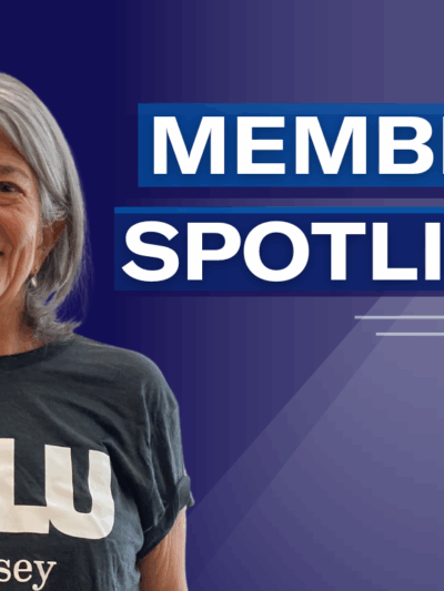 Women with grey hair in a grey Tshirt smiling against a dark blue background; includes the words "member spotlight"