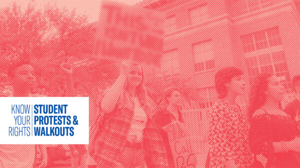 Students Holding protest signs outside of a school building