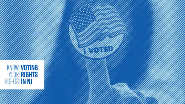 Woman with black hair holding up a "I voted" sticker
