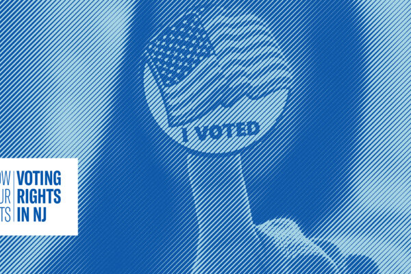 Woman with black hair holding up a "I voted" sticker