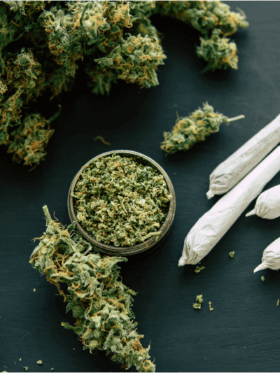 Joint and Grinder bud cannabis with crushed cannabis flowers