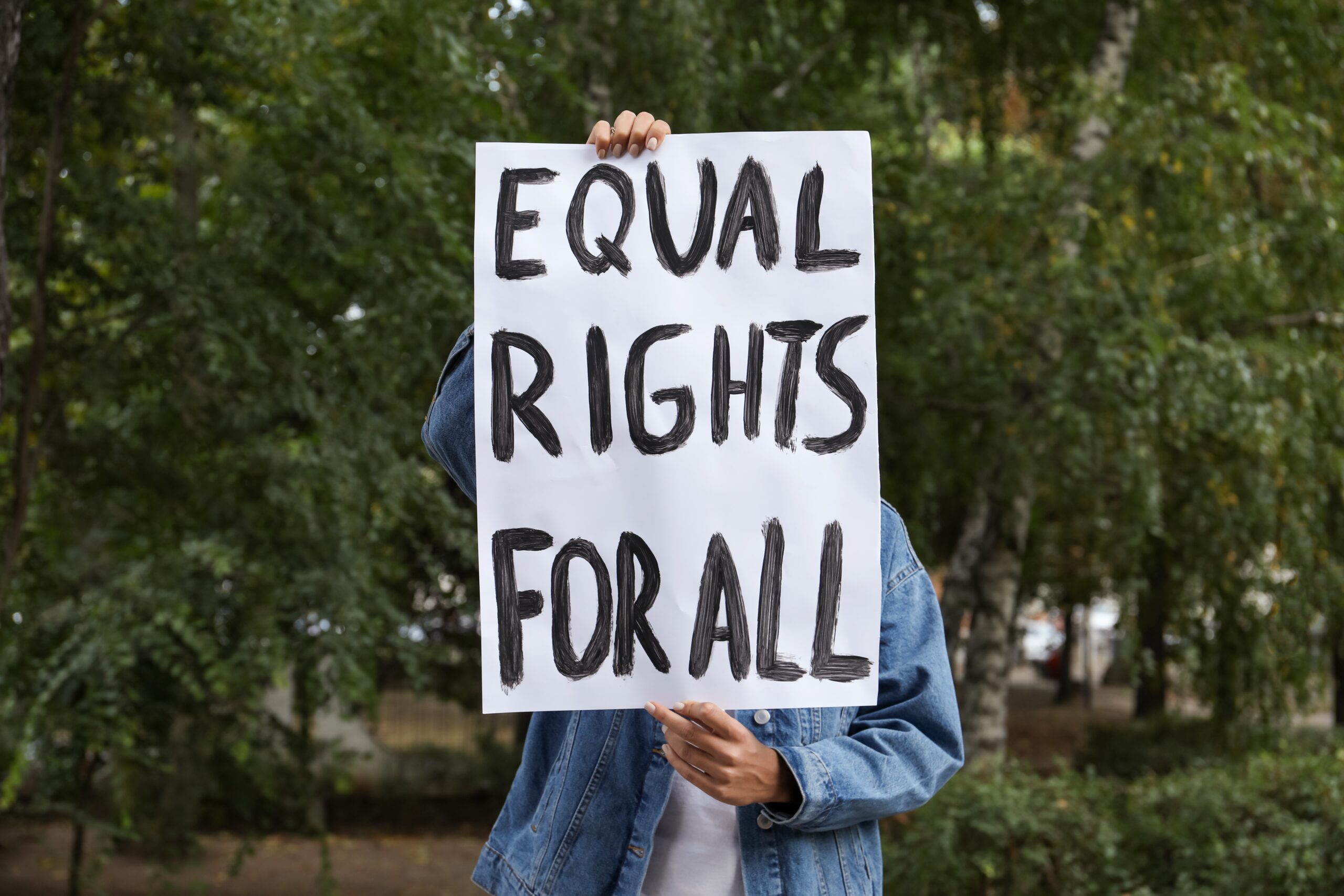 Hands holding a sign that reads