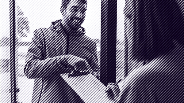 Man with brown hair and a beard holds a clipboard in front of a woman with medium length brown hair.