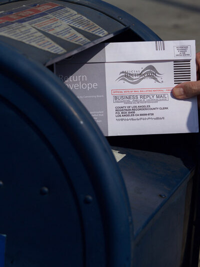 A mail in ballot placed in mail box.