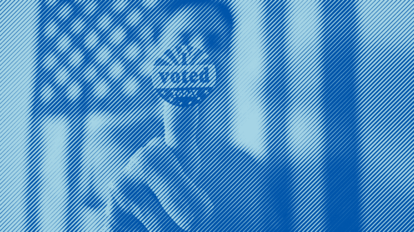 A man in front of an American flag holding an "I voted" sticker