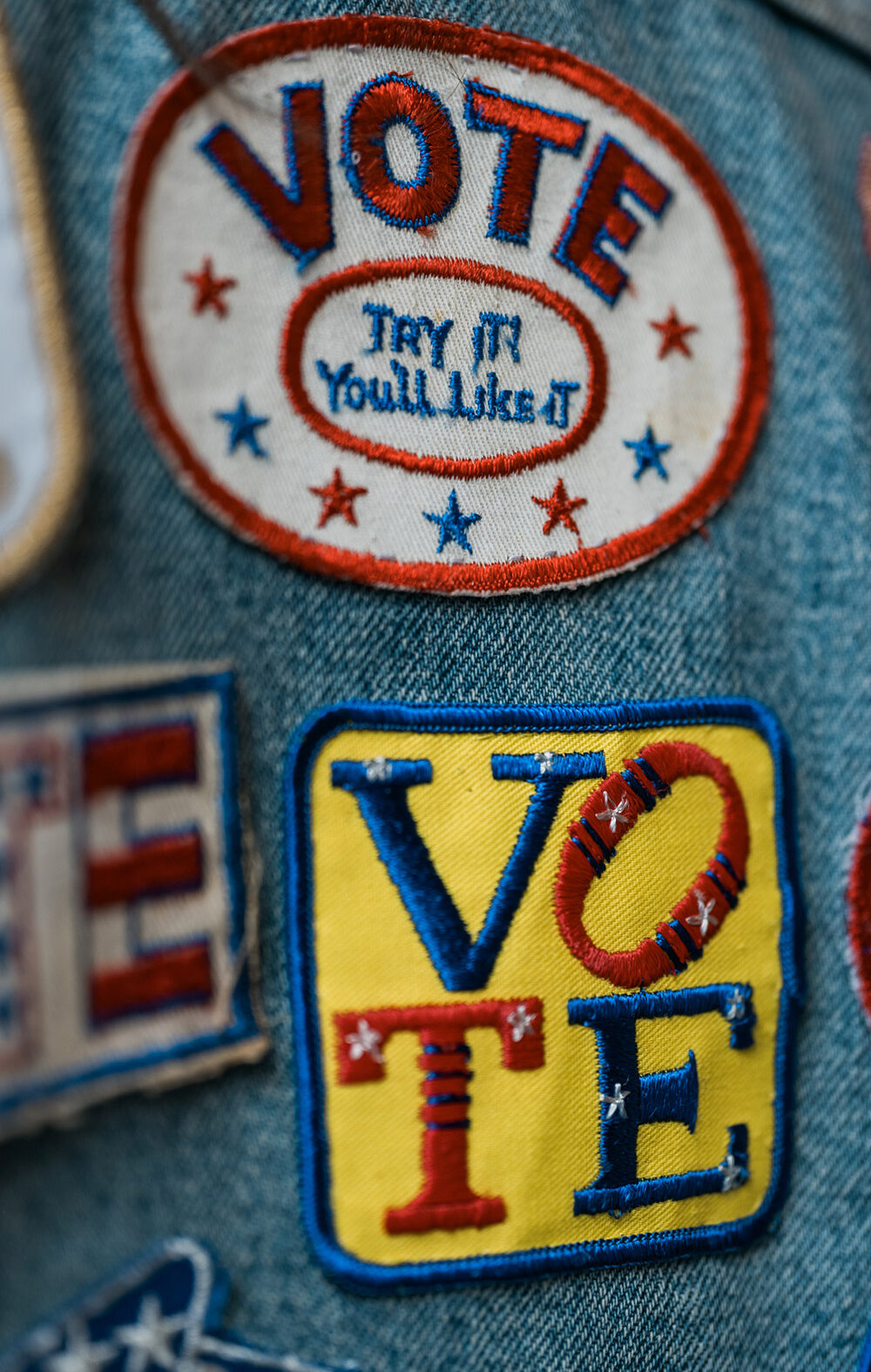 A group of patches on denim encouraging people to vote.
