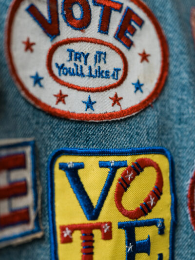 A group of patches on denim encouraging people to vote.