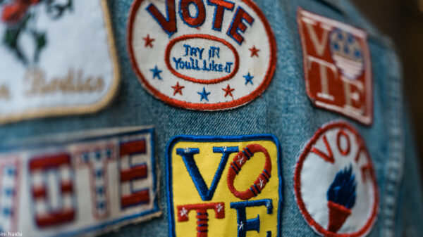 A group of patches on denim encouraging people to vote.