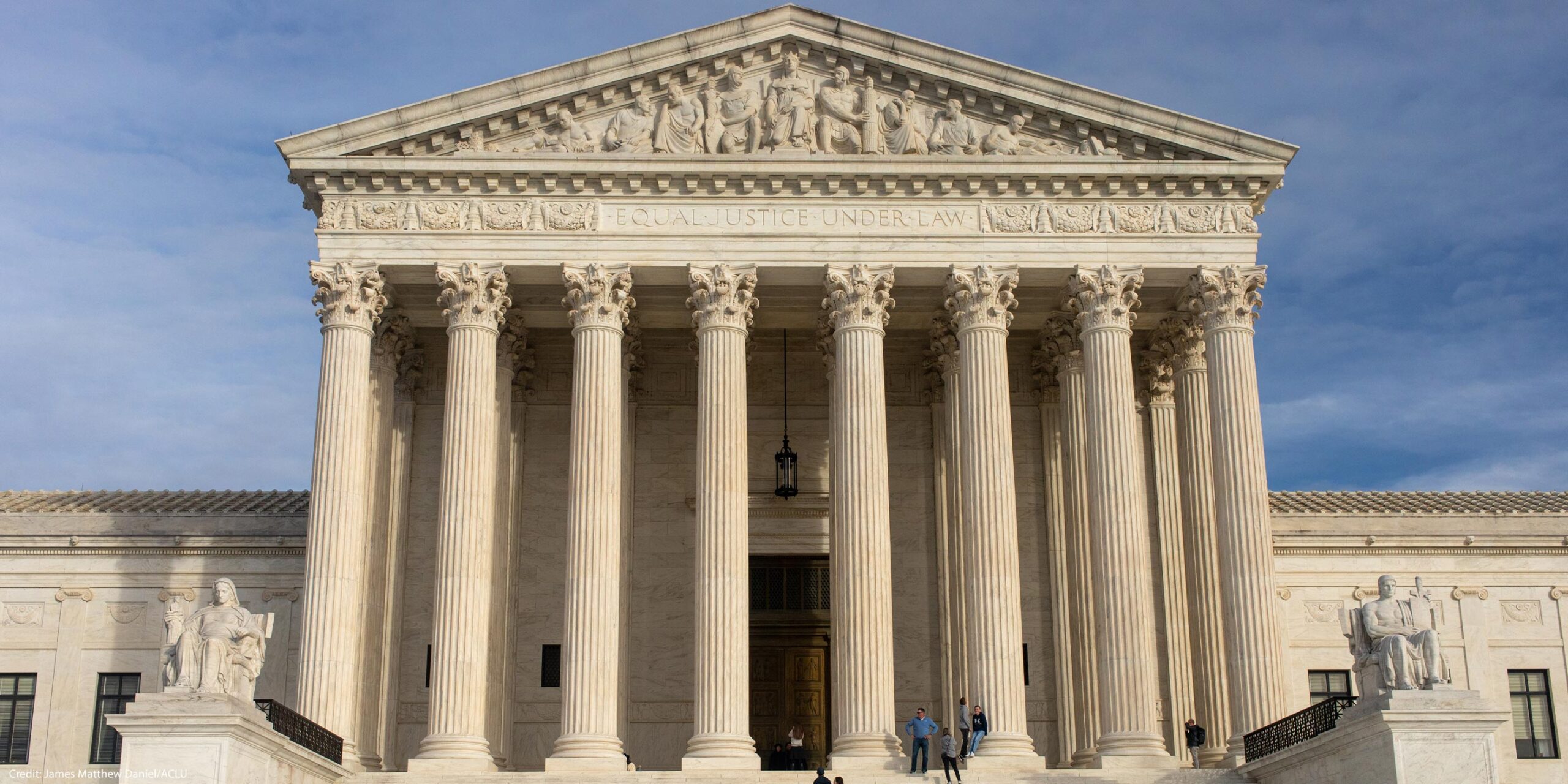 The facade of the Supreme Court of the United States building against a blue sky,