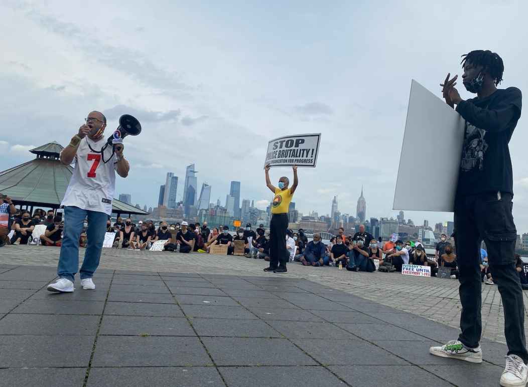 Zayid Muhammad holds a megaphone at a People's Organization for Progress rally