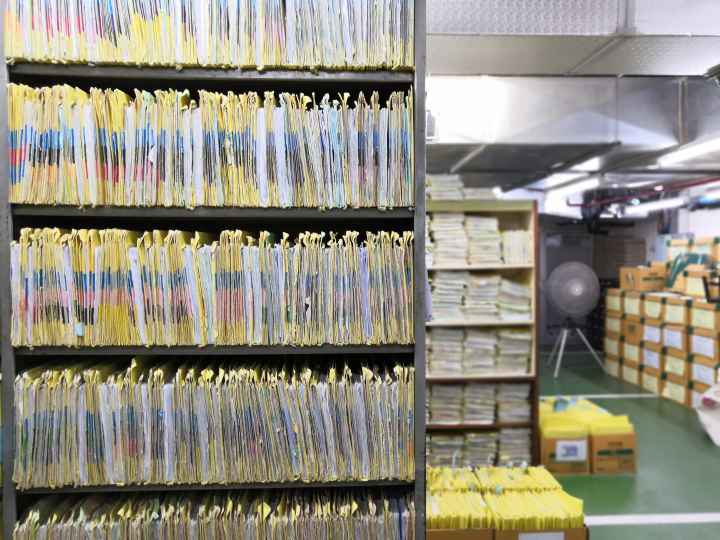A room with files packed on bookshelves in a room