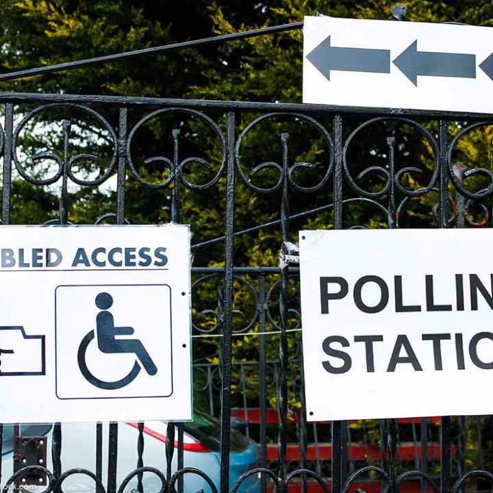 A polling station sign and disabled access sign.