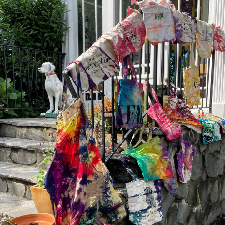 tie dye bags hanging over a railing in front of a white house